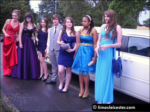 Friends stand with limousine prior to leaving for the school prom